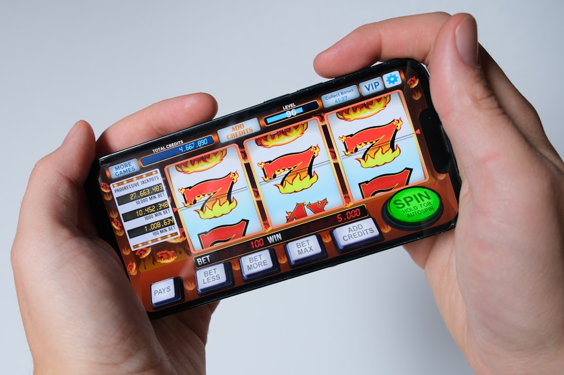 Tangan memegang ponsel untuk bermain game mobile