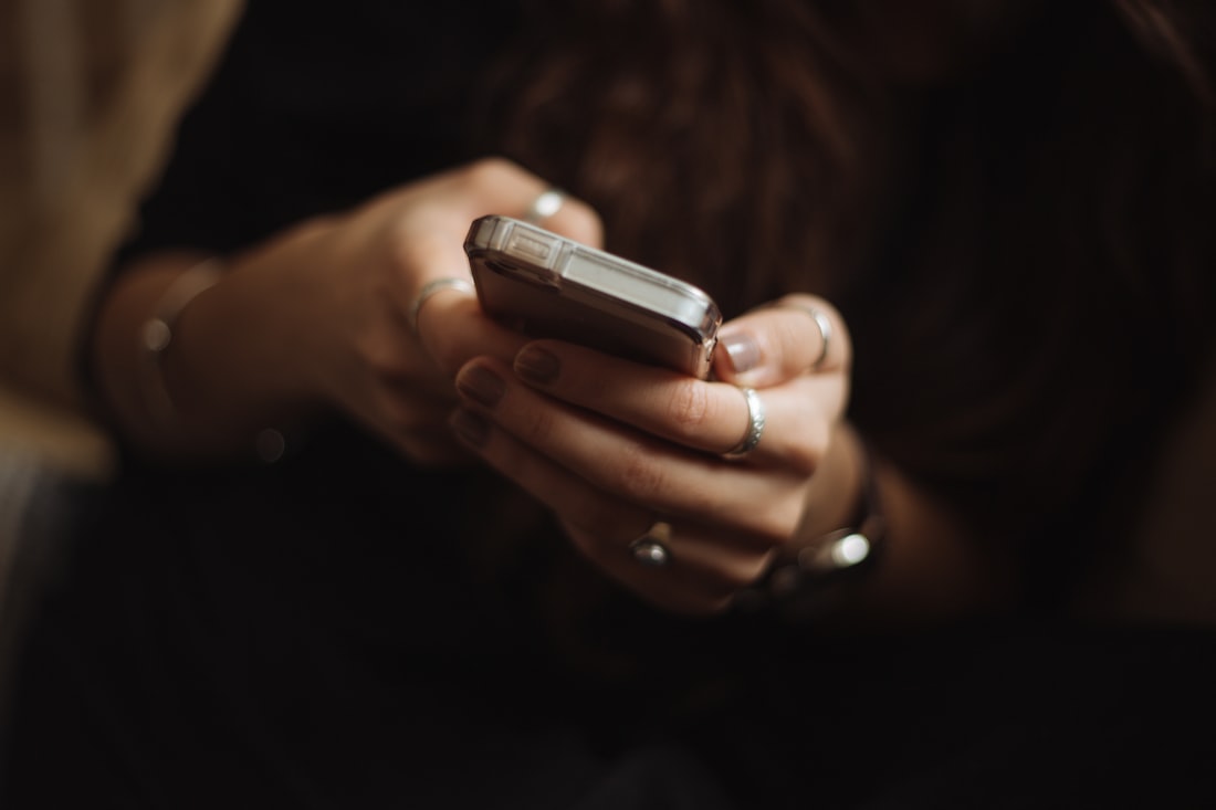 Pengguna menahan ponsel dengan dua tangan